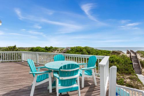 a table and chairs on a deck with a view of the ocean at 1398 - Alotta Coladas in Corolla