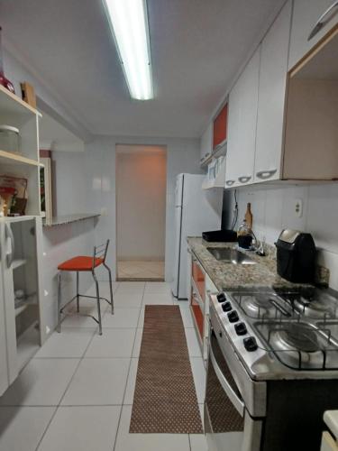 a kitchen with a stove and a refrigerator at Diamante guarapari in Guarapari