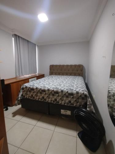 a bedroom with a bed in the corner of a room at Diamante guarapari in Guarapari