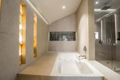 a large bathroom with a tub and a shower at Best Western Plus Santa Cecilia Pachuca in Pachuca de Soto