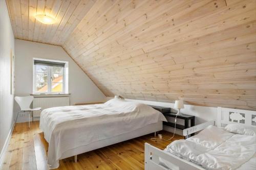 a bedroom with a white bed and a wooden ceiling at 20426-Samso-Nylandsvej-21 in Ballen