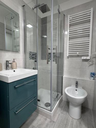 a bathroom with a shower and a sink and a toilet at Riviera Begonia Appartement - Parking Privé in Roquebrune-Cap-Martin