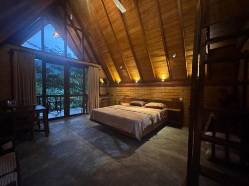 a bedroom with a bed and a large window at Rainforest Royal Heritage in Deniyaya