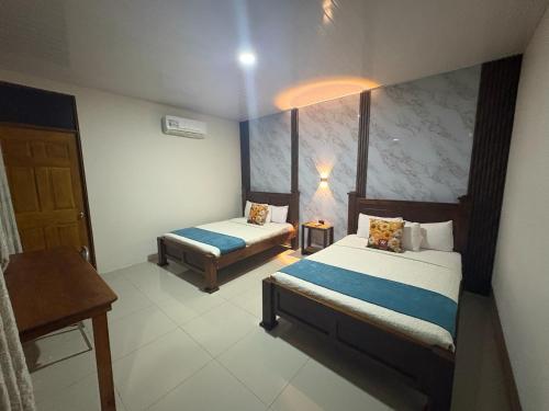 a hotel room with two beds and a table at Hotel Wilson Upala in Upala
