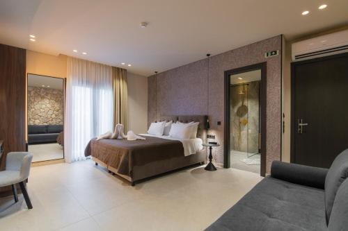 a bedroom with a bed and a living room at Alkioni Boutique Hotel in Pýli