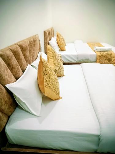 a row of beds with yellow pillows on them at Hotel Venus in Jabalpur