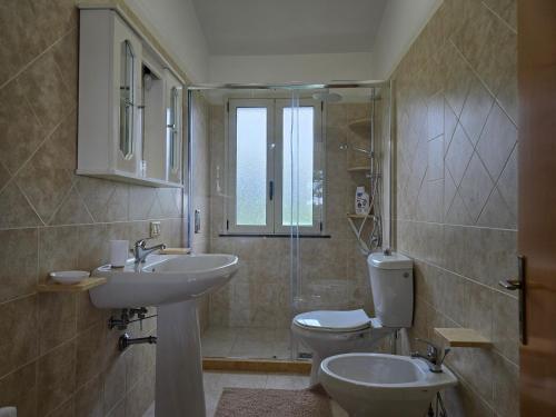 a bathroom with two sinks and a toilet and a shower at Villa Sara in Floridia