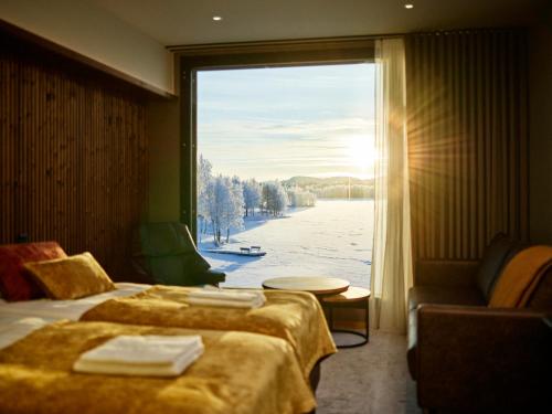 ein Hotelzimmer mit zwei Betten und einem großen Fenster in der Unterkunft Jauri Resort in Kemijärvi