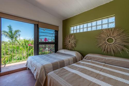 a bedroom with two beds and a large window at Quinta Rustica "La Aguacana" in Cuautla Morelos