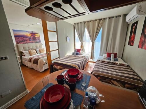 a room with two beds and a table with plates on it at Living Suite in El Cerrillo