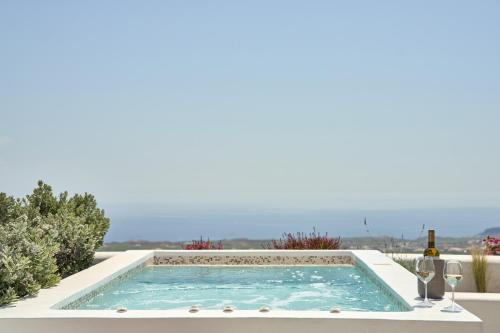 a pool with a table and a bottle of wine at Alleys All-Suite Hotel & Spa in Pyrgos