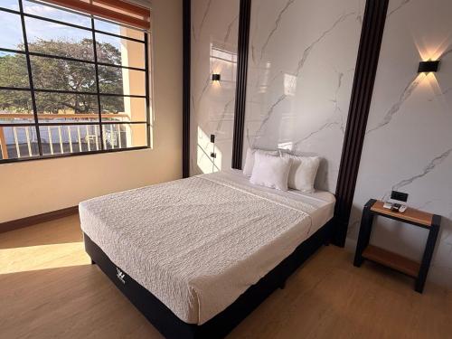 a bedroom with a bed and a large window at Hotel Wilson Santa Cruz in Santa Cruz