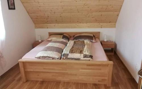 a wooden bed with pillows on it in a room at Chaty Slovensky Raj Veronika in Smižany