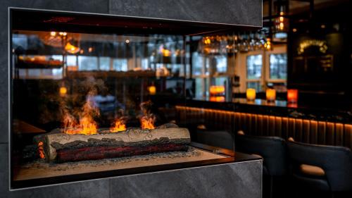 a fireplace in a restaurant with fires in it at Hotel Middelburg in Middelburg