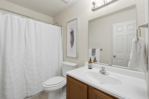 a white bathroom with a toilet and a sink at The Alturas in Alamogordo