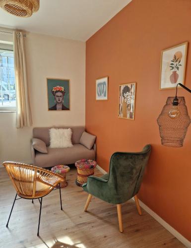 a living room with a couch and a chair at Les appartements de Lucie in Eaux-Bonnes
