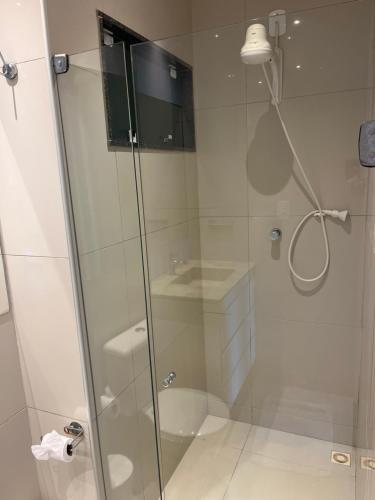 a bathroom with a shower with a glass door at Vizinho dos Parapente - Novo Luxo apartamento in Canoa Quebrada