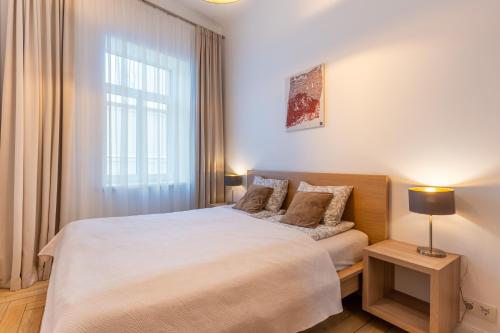 a bedroom with a large bed and a window at Picturesque Old Town Apartment with Charming Balcony in Kaunas