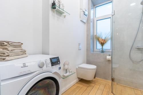 a washing machine in a bathroom with a shower at Picturesque Old Town Apartment with Charming Balcony in Kaunas