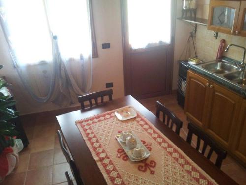 SìnnaiにあるB&B Gli Archiの木製テーブル、テーブル、テーブル付きのキッチンが備わります。