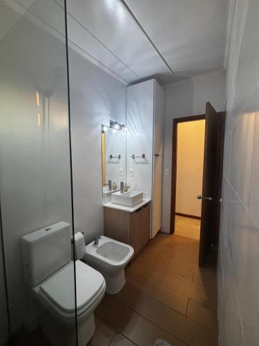 a bathroom with a toilet and a sink at La Hojarasca in Termas de Guaviyú