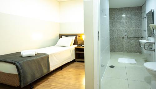 a bathroom with a bed and a shower and a toilet at Travel Inn Express Hotels Brás in São Paulo