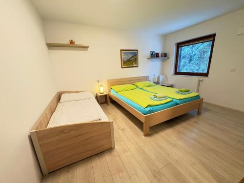 a bedroom with two beds and a window at Triglav NP Apartment - above Bled in Zgornje Gorje