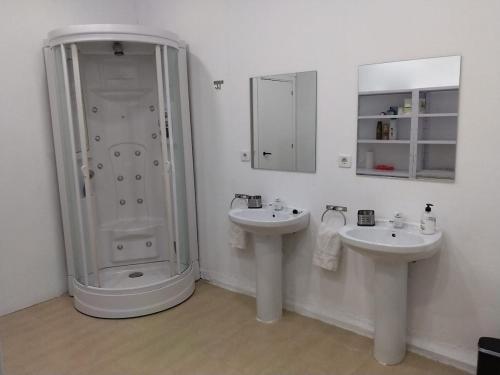 a white bathroom with two sinks and a shower at Cádiz bahía in Cádiz