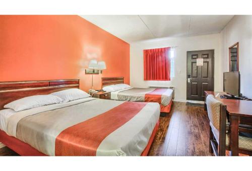 a hotel room with two beds and a desk at Motel 6-Windsor, ON in Windsor