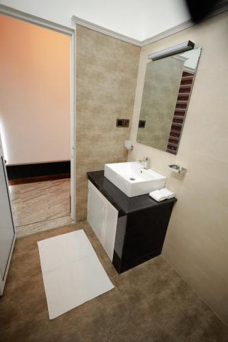 a bathroom with a sink and a mirror at Yellow Rose Hotel in Kandy