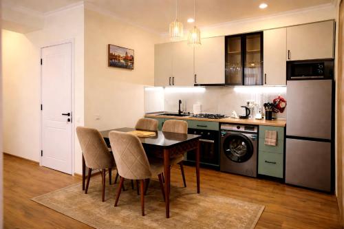 a kitchen with a table and chairs and a refrigerator at Stylish House in Kutaisi