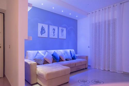 a living room with a couch with blue walls at Suite Benvenuti al Sud in Crotone