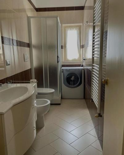 a bathroom with a toilet sink and a washing machine at Suite Benvenuti al Sud in Crotone