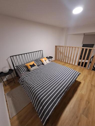 a bedroom with a bed with a striped blanket at ApartmánPohoda in Opava