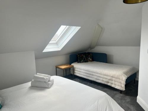 a attic bedroom with two beds and a skylight at Upper Valley View in Keynsham