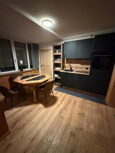 a kitchen with a table and chairs in a room at FeWo's und Apartment's Blaues Haus in Davos