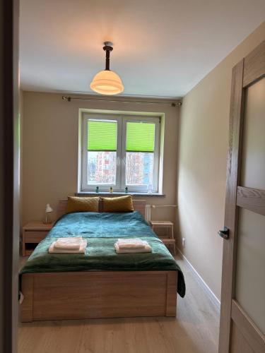 a bedroom with a bed with two towels on it at Rodzinna Przystań in Białystok