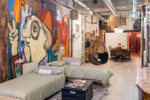 a room with three beds and a painting on the wall at Loft artístico Espacio Lirola Centro in Granada