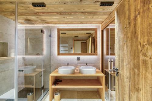 a bathroom with two sinks and a mirror at Central High-End Duplexes, Sauna and Stove in Champéry