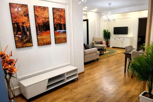 a living room with four paintings on the wall at Stylish House in Kutaisi