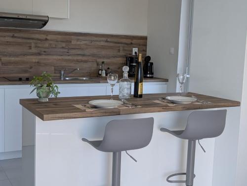eine Küche mit einer Holztheke mit zwei Hockern in der Unterkunft Villa Debriz Apartment in Stréfion