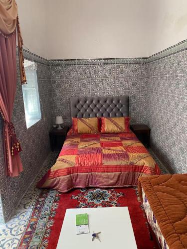 a bedroom with a bed and a table in it at Cosy Riad Cœur Medina in Rabat