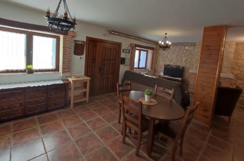 a living room with a table and a couch at Alameda II con CHIMENEA Salòn y BARBACOA en patio in Curiel de Duero