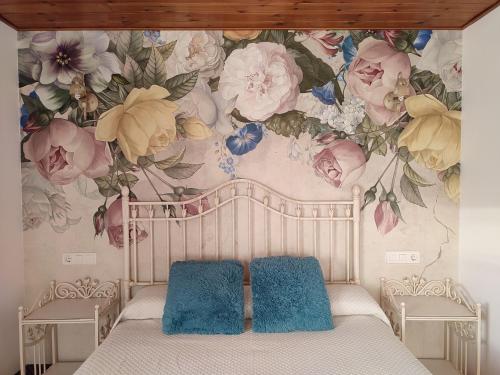a bedroom with a bed with a floral wallpaper at Alameda II con CHIMENEA Salòn y BARBACOA en patio in Curiel de Duero