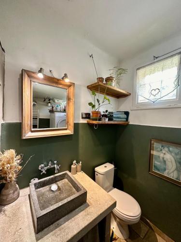 a bathroom with a sink and a toilet and a mirror at Cocon en Provence à Ménerbes in Ménerbes