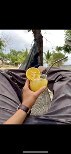 a person holding a drink with an orange slice at Raimy Sumaq in Arenillas