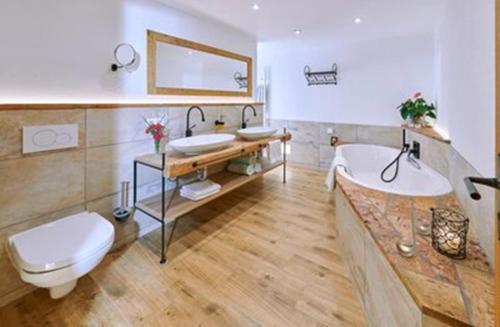 a bathroom with two sinks and a tub and a toilet at Bauernhof Berndlhof Obing in Obing