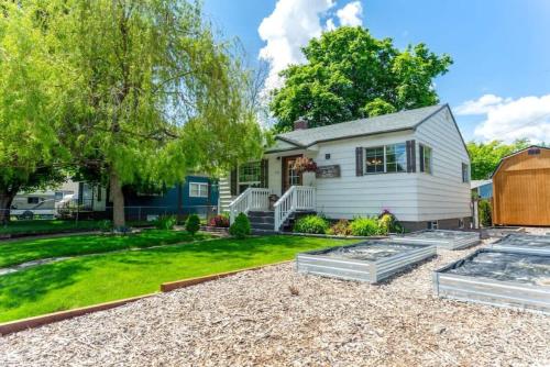 a house with a garden and a yard with a driveway at Copper Voyage, Fenced Backyard in Coeur d'Alene