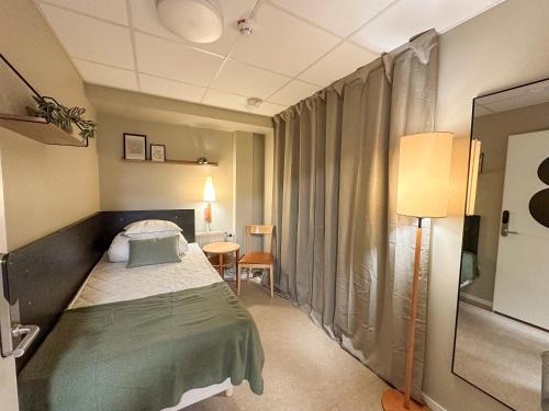 a small room with a bed and a window at Nässjö Vandrarhem in Nässjö