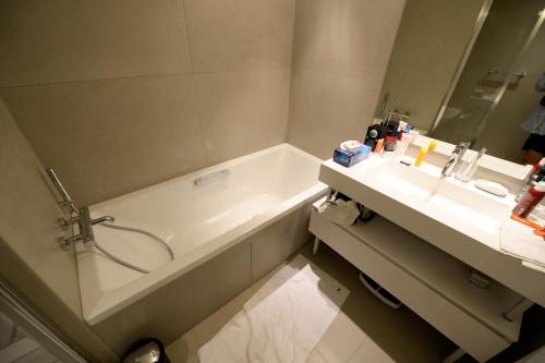 une salle de bain avec une baignoire et un lavabo dans l'établissement Chamonix Balcons du Mont Blanc, à Chamonix-Mont-Blanc